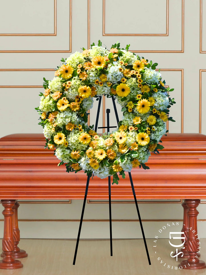 Corona de Condolencias Luz Eterna arreglo de condolencias con 12 gerberas amarillas + margaritas