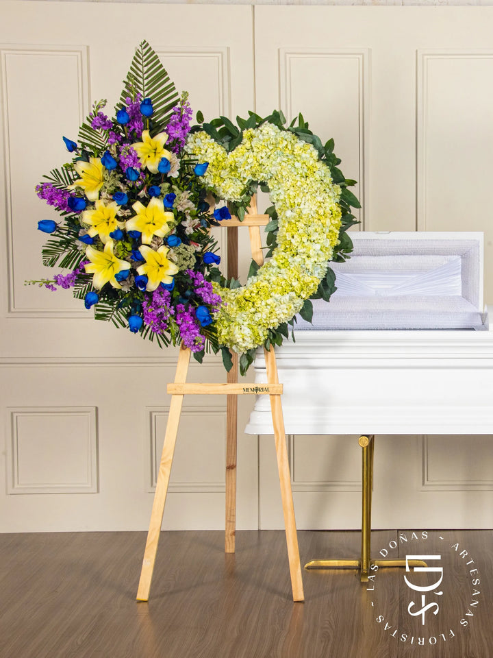 Corona de Corazón con Hortensias, Rosas Azules y Liliums arreglo de condolencias con 24 rosas azules