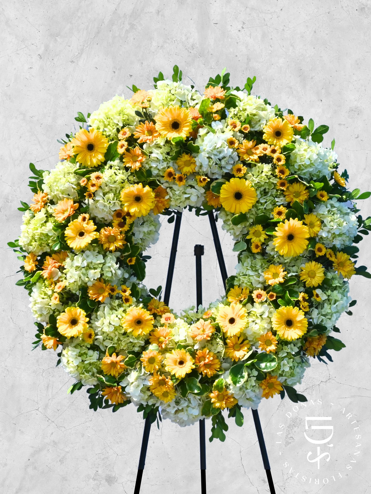 Corona de Condolencias Luz Eterna arreglo de condolencias con 12 gerberas amarillas + margaritas