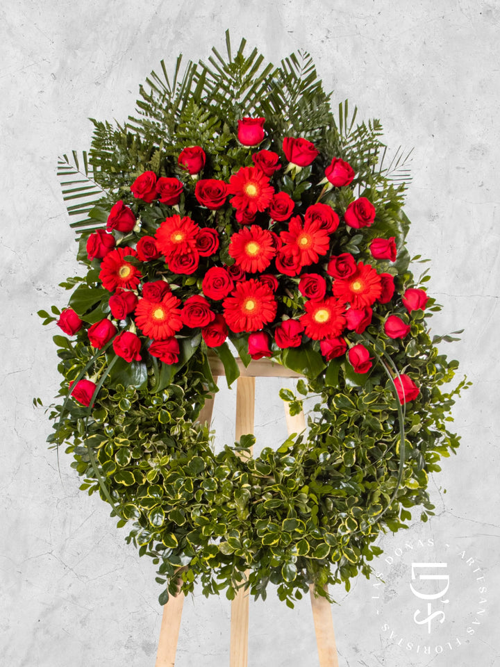 Corona Circular de Coprosma con Rosas Rojas y Gerberas arreglo de condolencias con 48 rosas rojas